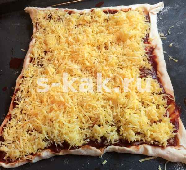 Натри сыр на мелкой терке и щедро засыпь пиццу большим слоем сыра.